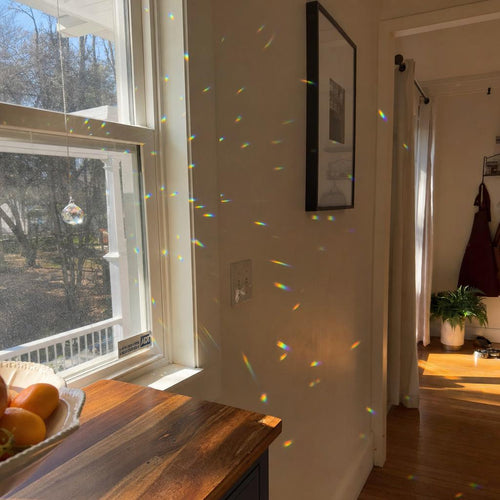Rainbows across the room from the crystal suncatcher